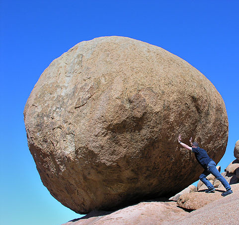 Man pushing on rock