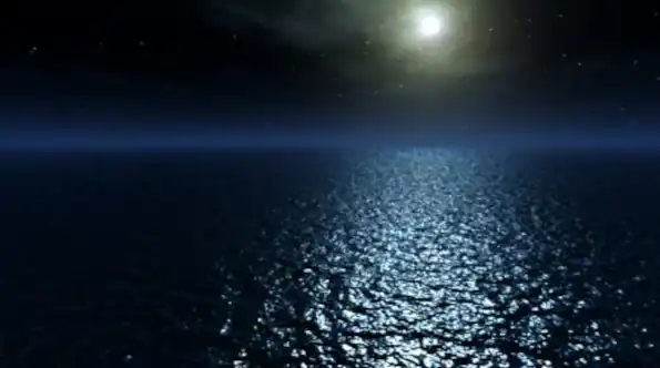 Full moon rising over ocean at night
